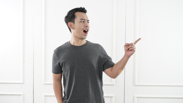 South east asian man yelling at side, angry expression