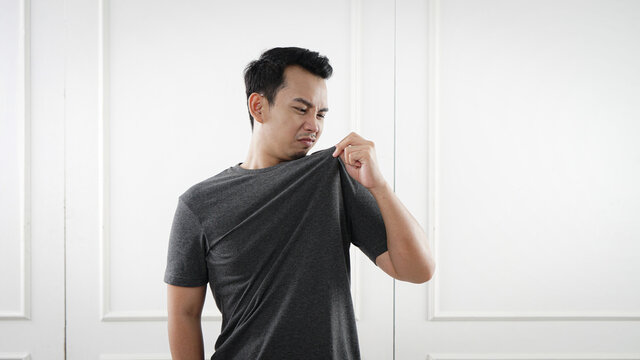 Man smelling shirt, odor photo concept