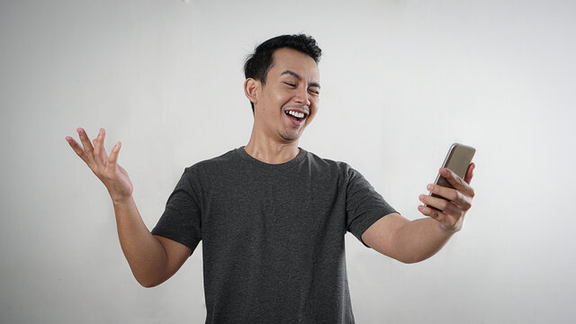 Man looking at phone with happy expression