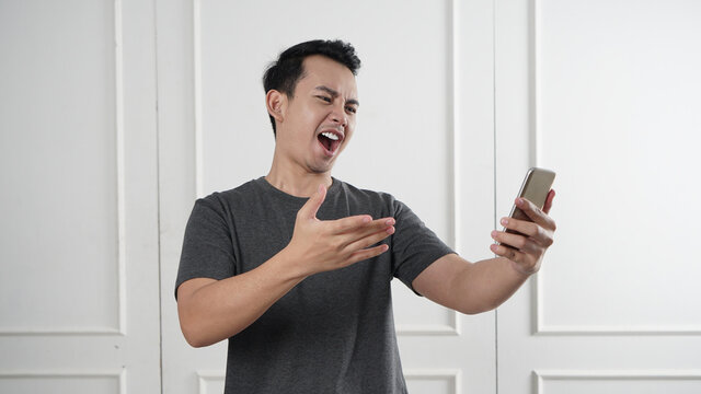 Man pointing on his phone with angry face