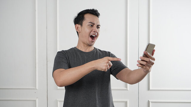 Man pointing on his phone with angry face