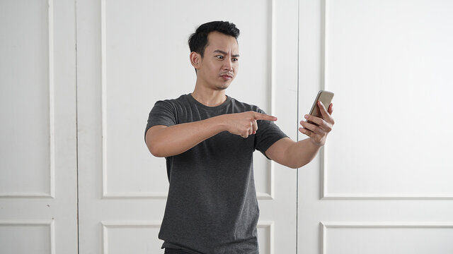 Man pointing on his phone with angry face