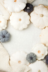 Autumn composition. Feminine desk table with knitted scarf and white squash pumpkin on white background. Flat lay, top view. Nordic, hygge, cozy home concept, monochrome, copy space