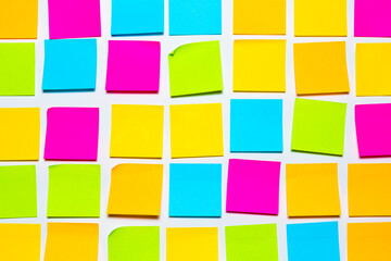 Colorful blank sticky notes on white wall isolated background. Reminder and business office...