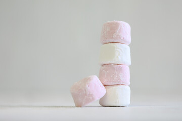 Pink and white marshmallows on plain white background with copy space