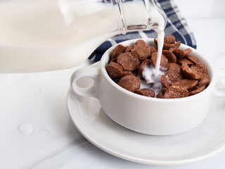 Cocholate cereal with milk on a white bowl