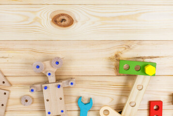 A colorful wooden building kit for children on wood. Set of tools, wooden robot on wooden table. Games and tools for kids in preschool or daycare. Natural, eco-friendly toys.