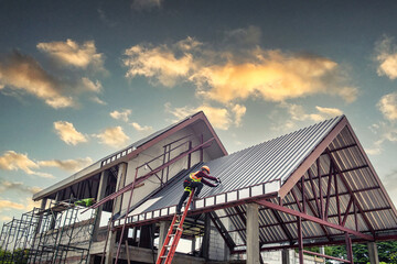 Worker man building tradesman on the roof of a house . with safety helmet, new home, construction...