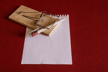 A fountain pen on a mousetrap on a sheet of writing paper for notes.