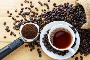 Hot coffee espresso or americano and coffee bean on older wood table at morning time. Coffee break time.