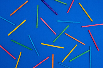 some multicolored sticks on a blue surface	