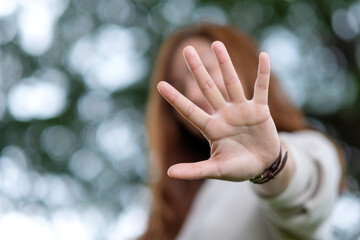 Portrait image of a beautiful young asian woman raising hands and playing with camera in park