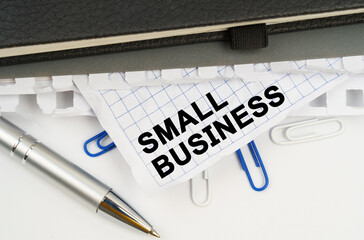 On the table is a pen, notebooks and a crumpled sheet of paper with the inscription - SMALL BUSINESS