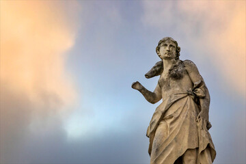 Fototapeta premium Antica statua abbandonata con cielo colorato.