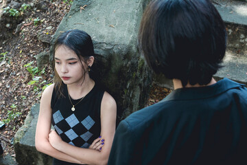 An upset teenage girl refuses to look at her remorseful boyfriend asking for forgiveness....