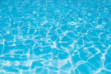 Blue water surface in swimming pool with sun reflection,  Ripple wave in pool for background and abstract