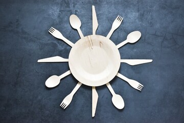 Fototapeta na wymiar Set of environmentally friendly bamboo cutlery and plates on a gray background laid out in the form of a clock. Free plastic concept. Zero waste concept. Place for your text. Flat lay.