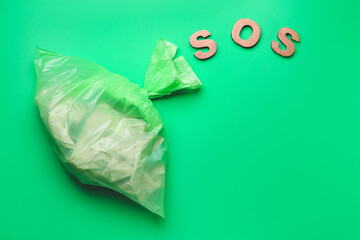 Bag with garbage and word SOS on color background. Ecology concept