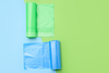 Rolls of garbage bags on color background