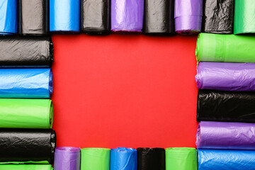 Frame made of garbage bags on color background