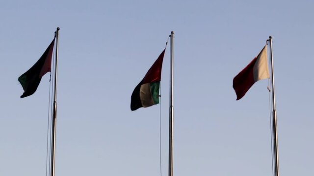 Dubai, UAE - 07.22.2021 UAE flags floating with red and white flags with blue sky on background