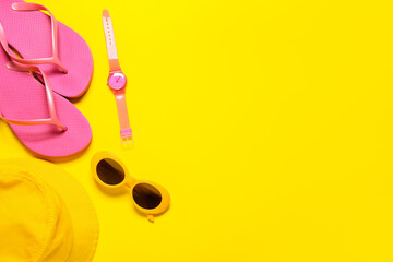 Stylish sunglasses, hat, wrist watch and flip-flops on color background