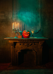 Scary laughing pumpkin and old skull on ancient gothic fireplace. Halloween, witchcraft and magic.