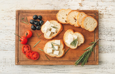 Sandwiches with feta cheese on white wooden background