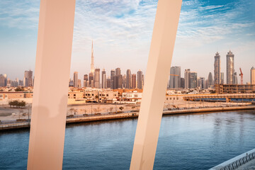 Fototapeta premium Luxury high skyscrapers with offices, hotels and residential buildings in UAE. View from pedestrain footbridge over water canal