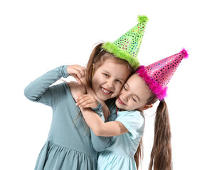 Cute little sisters in party hats on white background