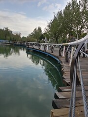 a lake in park with wooden bridge