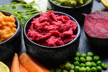 Bowls with tasty hummus on dark background, closeup