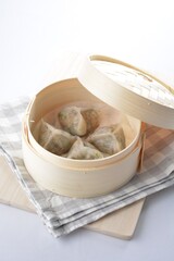 steamed handmade crystal vegetable prawn dumpling in bamboo basket white background dim sum Halal menu