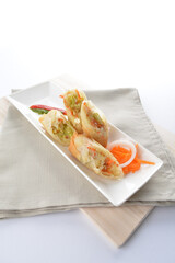 deep fried vegetable spring roll in long plate in white background dim sum snack Halal menu