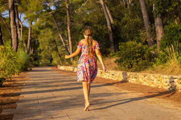 A young girl is walking barefoot on the path, Mali Losinj, Croatia