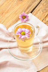 Fototapeta na wymiar Cup with tasty floral tea on wooden background