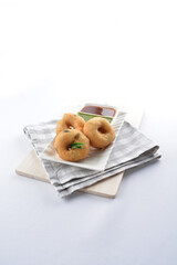 Indian vegetable deep fried donut in green yogurt and red chilli sauce in white background vegan dim sum Halal menu