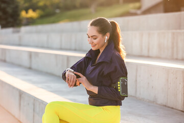 Sporty young woman with fitness tracker outdoors