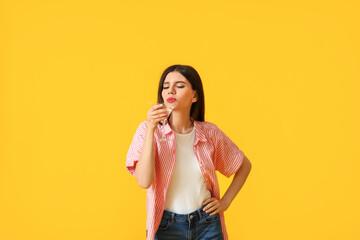 Beautiful young woman with cocktail on color background