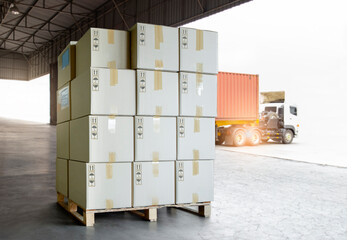 Package Boxes on Pallet Load with Shipping Cargo Container. Trailer Truck Parked Loading at Dock Warehouse. Delivery Service. Distribution Warehouse Logistics. Cargo Freight Truck Transportation.	