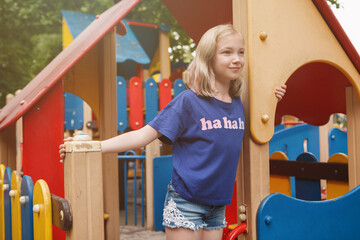 Cheerful young girl having fun on park playground