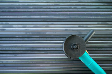 angle grinder on steel. background from steel pipes. shaped metal pipes. several metal pipes lie side by side. lines created by pipes. making a fence.