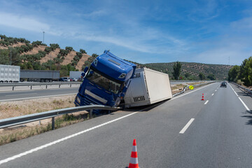 Fototapeta na wymiar Truck with an accident refrigerated semi-trailer, overturned by the exit of the highway in the median of the highway.