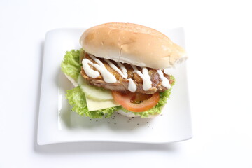 speciality grill bbq chicken burger with sliced cheese and vegetables in white background western fast food halal menu