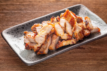tasty slice fried pork in rectangular ceramic plate on rustic natural wood texture background