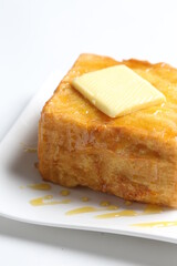 thick egg french toast with butter and honey in white background snack halal menu