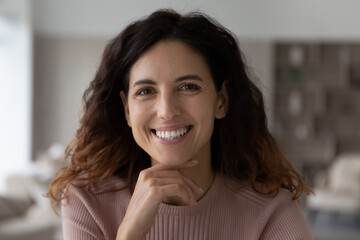 Close up profile picture of smiling millennial Hispanic woman look at camera feel optimistic confident. Portrait of happy young Latino female client or customer posing. Diversity, laughter concept.