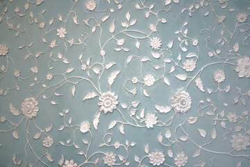 Details and elements of architecture and interior. Handmade stucco of a white floral pattern...