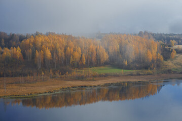 Shore of Gorodischenskoye Lake on a foggy October morning. Izborsko-Malskaya valley. Pskov region, Russia