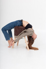 young caucasian attractive woman with long brown hair in blue jeans, suit jacket bending her body...
